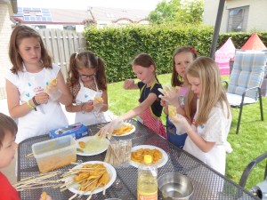 Meisjes maken kippestokjes klaar