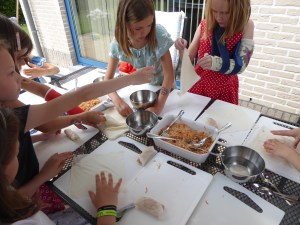 Foto's van meisjes die loempia's plooien